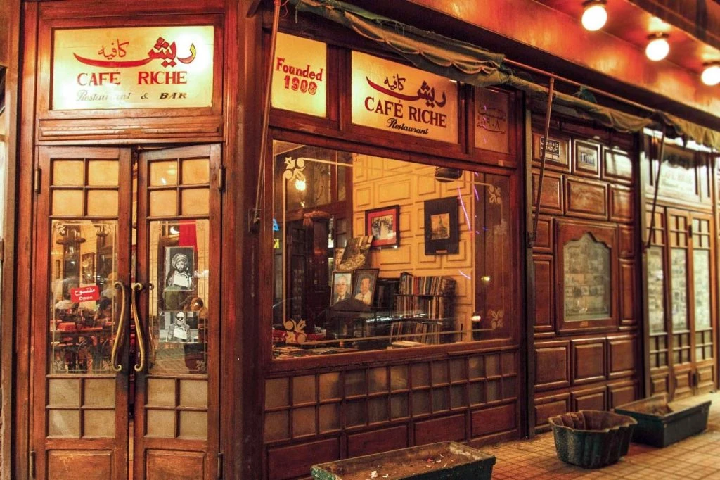 Friends sharing drinks at a lively downtown Cairo bar at night